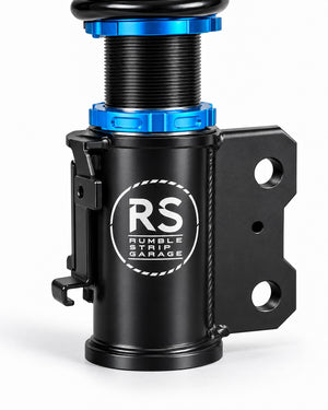 A close-up studio shot of a black cylindrical automotive component with bright blue anodized accents and a white 'RS RUMBLE STRIP GARAGE' logo on the side, set against a clean white background.